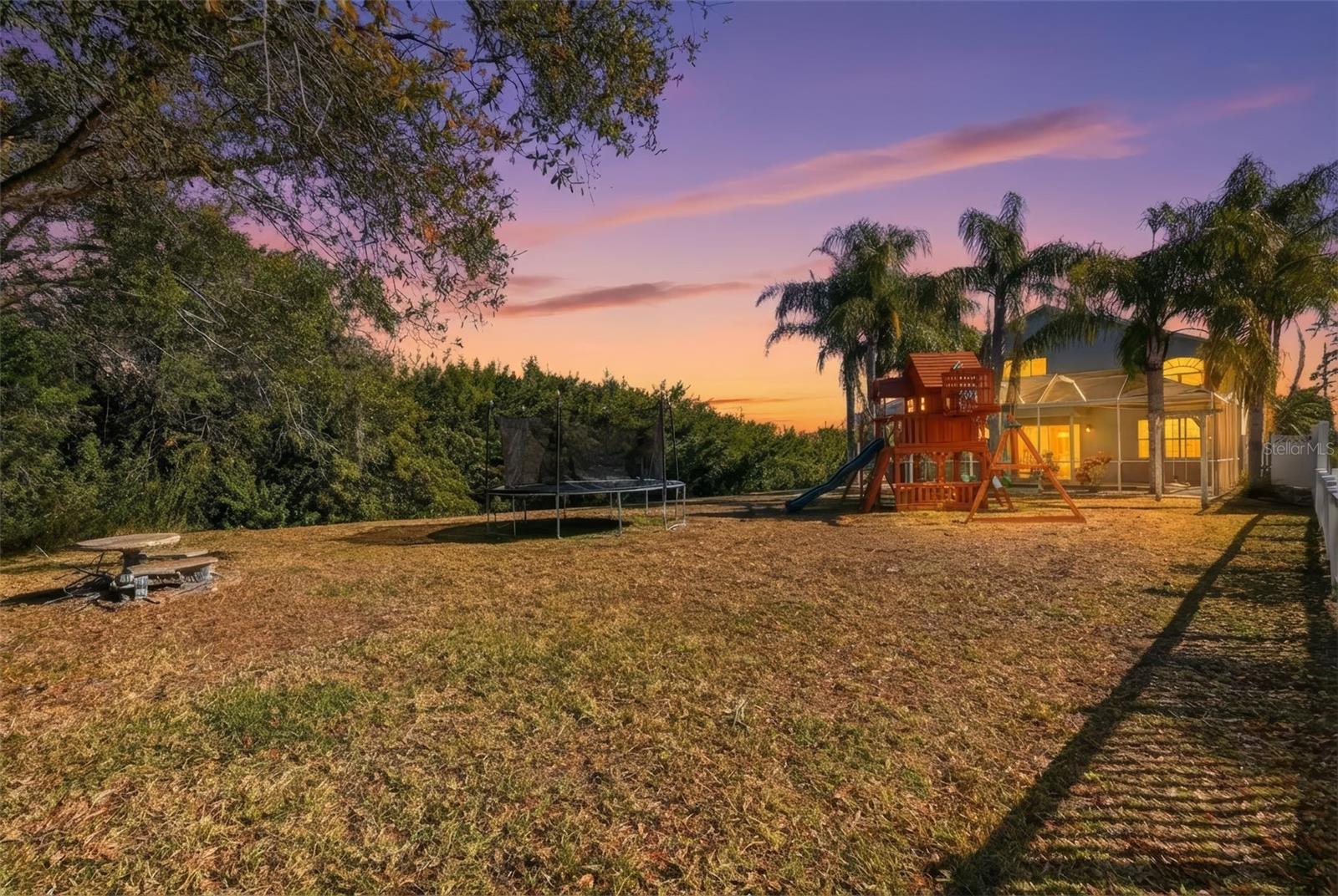 Twilight view of the large backyard and brand new jungle gym.