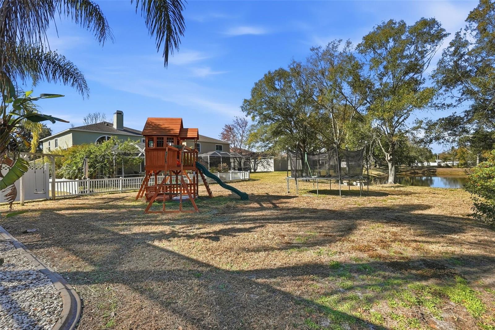 View of the backyard that connects directly to the pond.  Jungle gym and trampoline will convey.