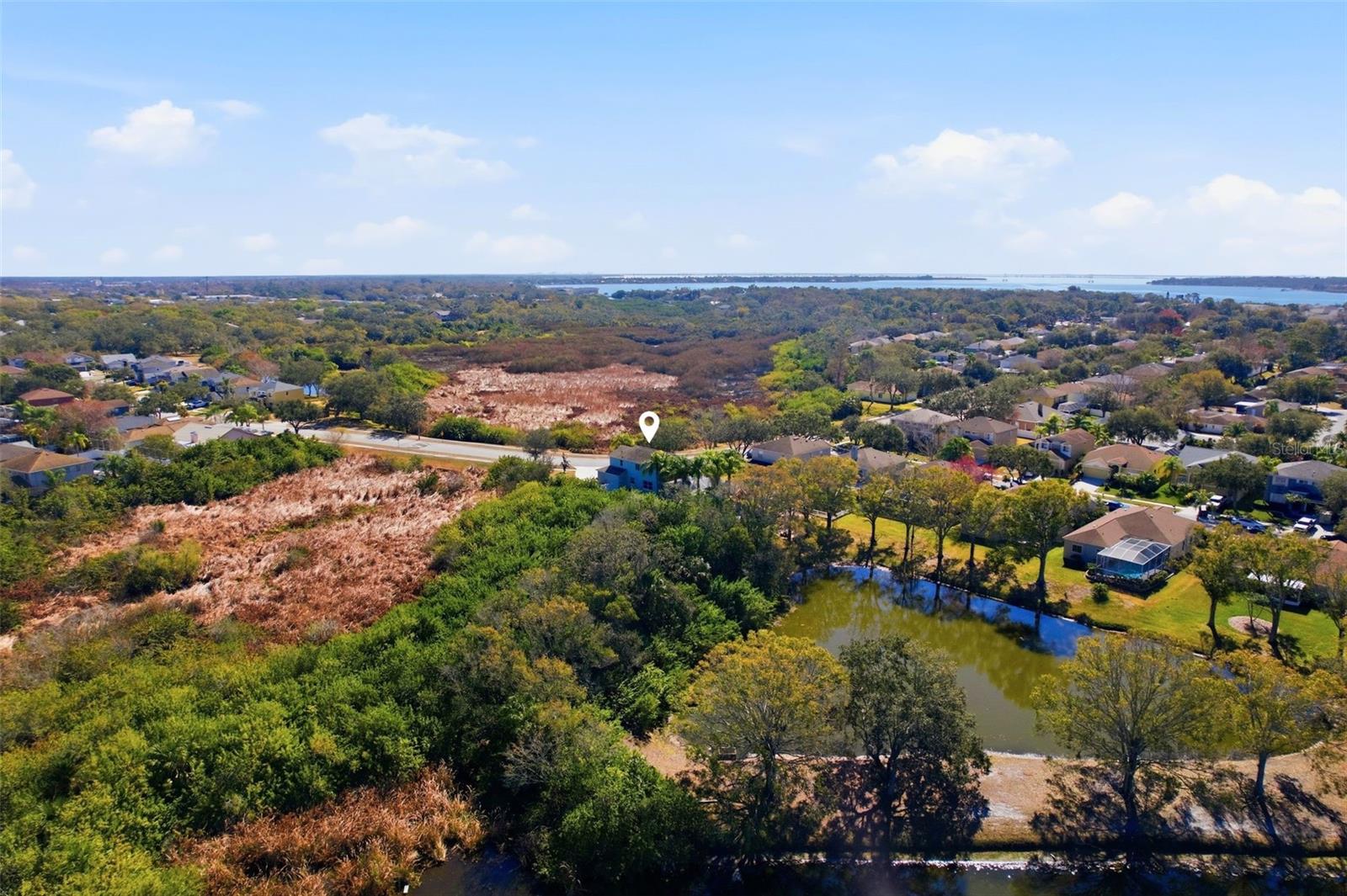 A different angle of the home with an aerial view and shows the pond.