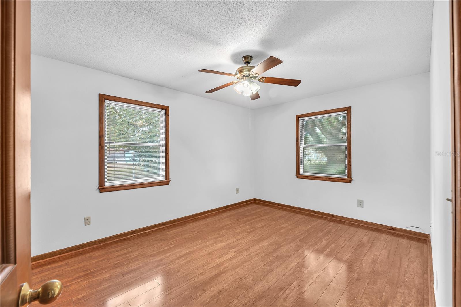 Primary Bedroom is 14' x 11' with wood floors, a built in closet and a ceiling fan.