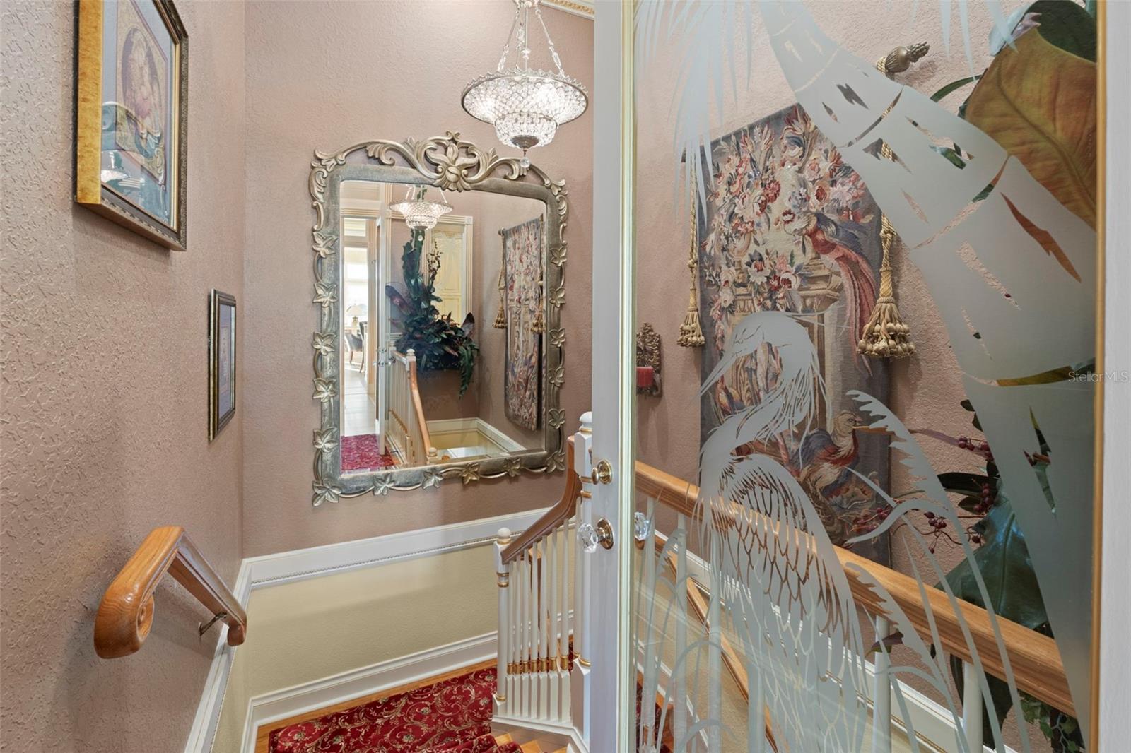 A custom glass door leads to the stairway and the lower level.
