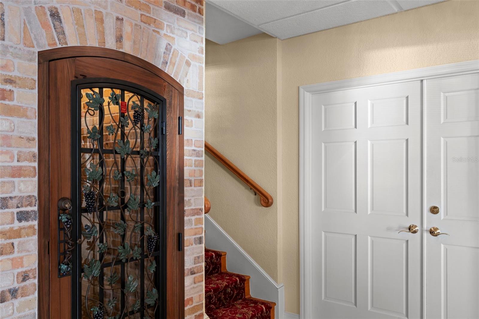 The wine room with stairs to the main living level and doors to one of the garages.