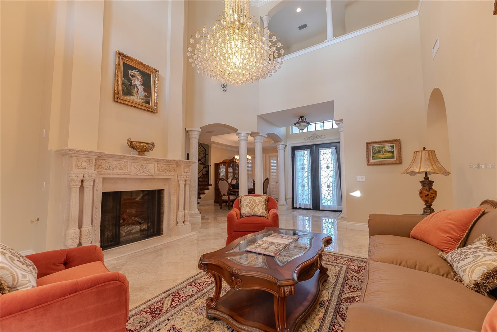 Light-filled formal living room showcasing a striking chandelier and timeless craftsmanship.