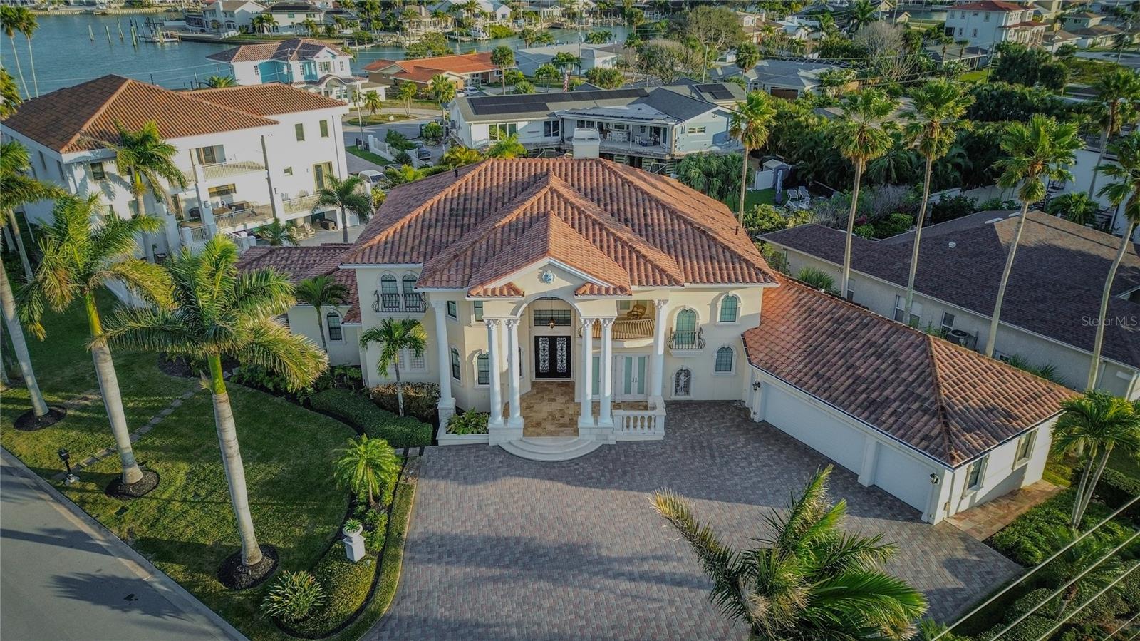 Mediterranean-inspired coastal estate with tile roof and elevated construction.