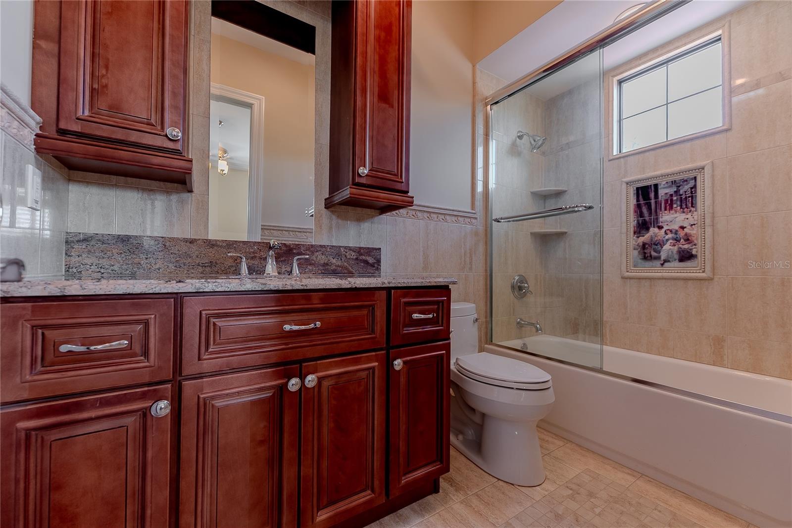 Designer guest bath with stone surfaces and custom tile.