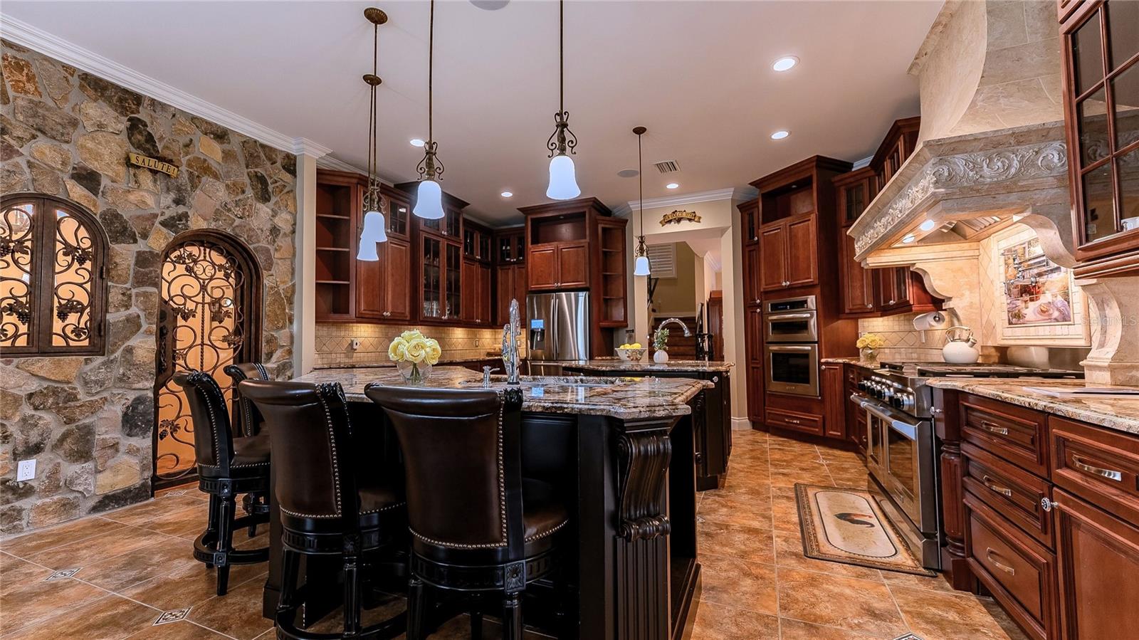 Chef’s kitchen with custom wood cabinetry, granite countertops, wine cellar