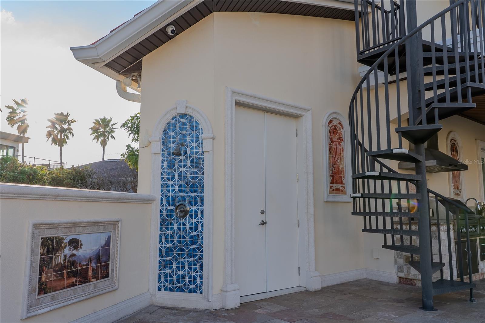 Private outdoor shower beneath the spiral staircase, ideal after a swim.