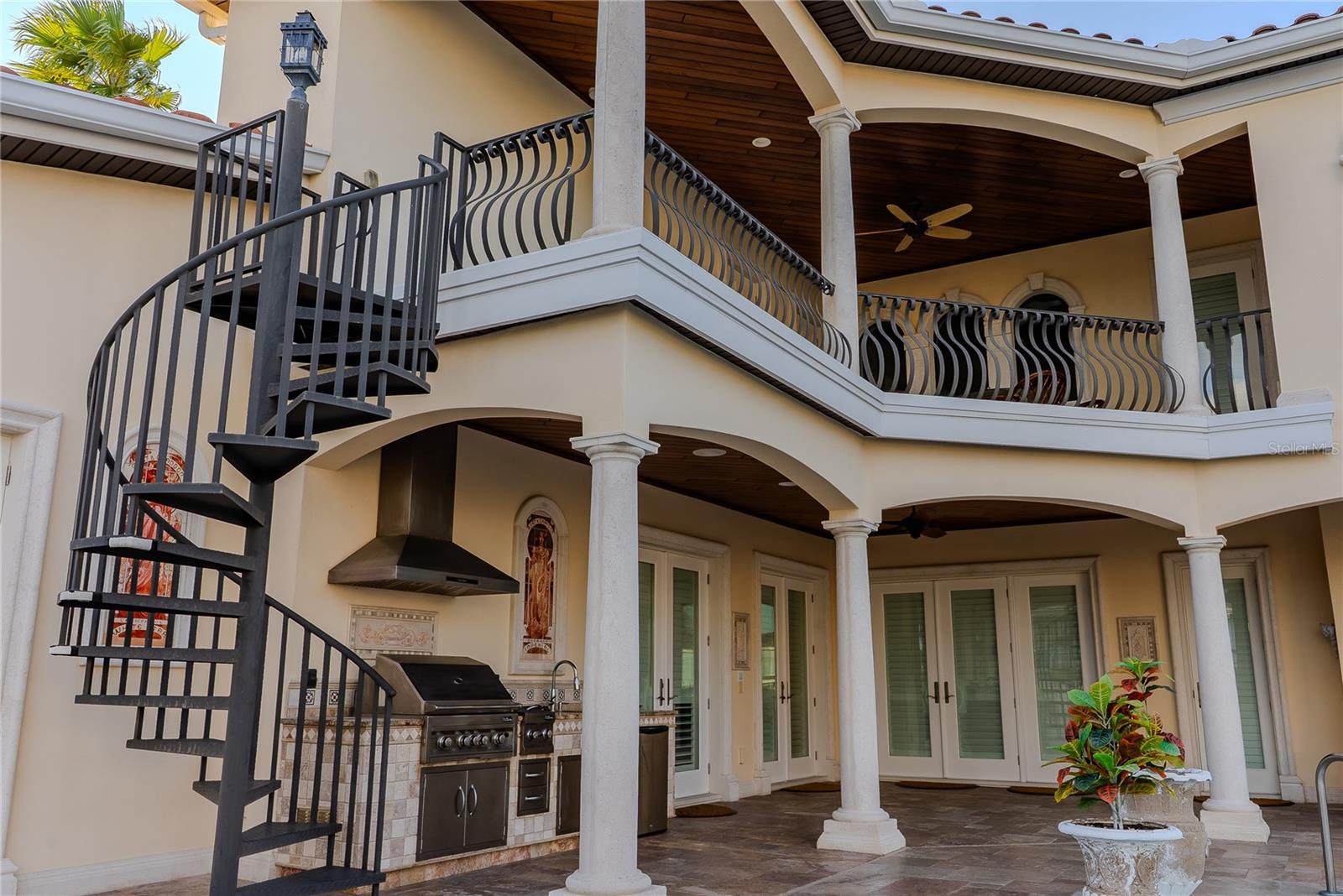 Private courtyard view of the home’s rear façade and signature spiral stair.