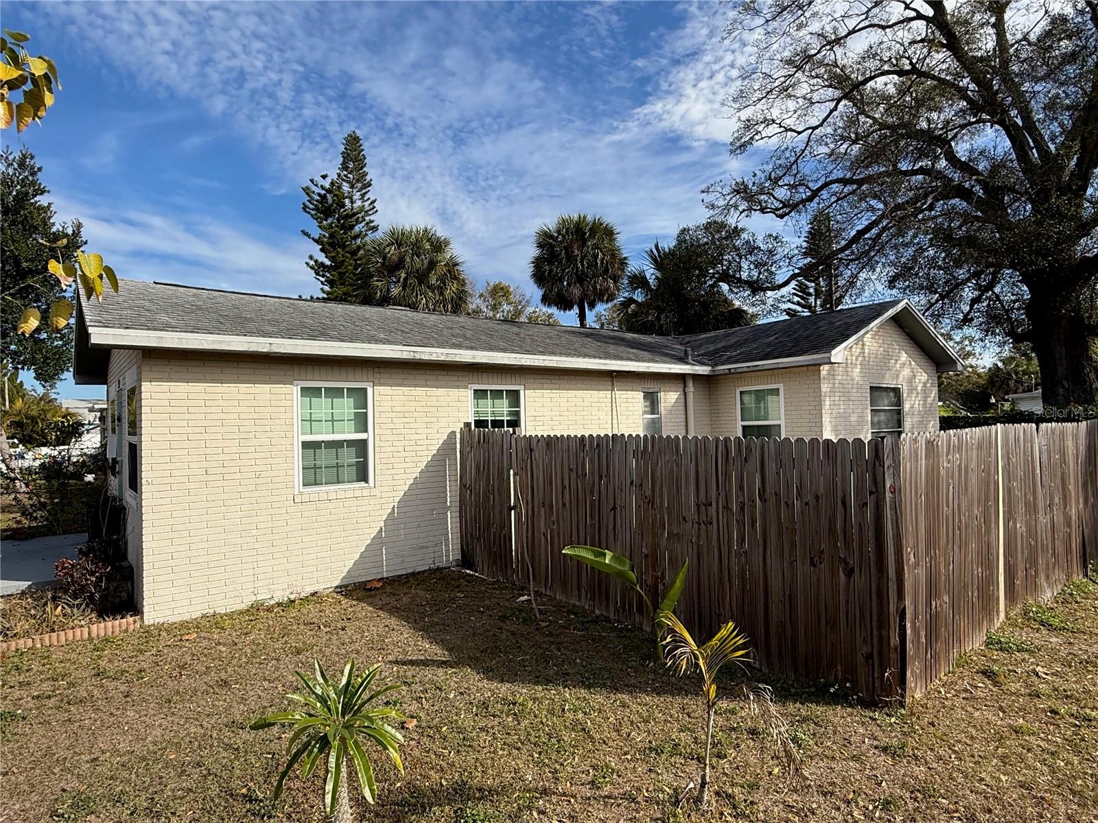 View of south side of home, with fenced side yard.