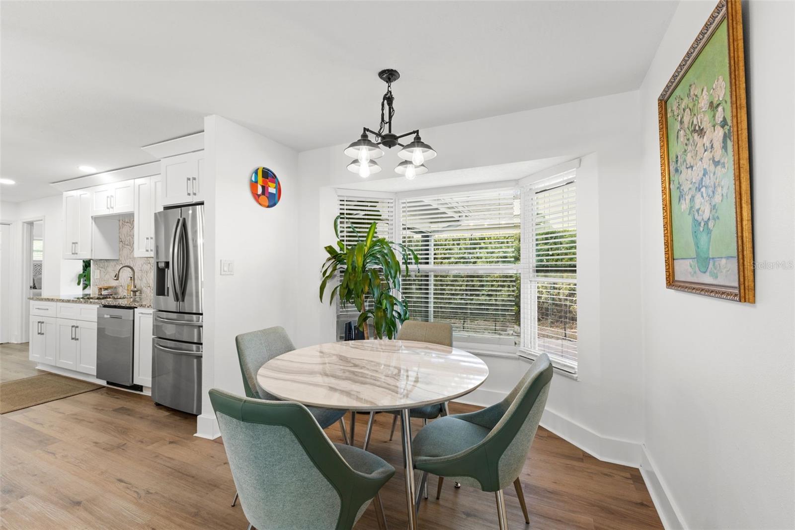 Inviting dining space with direct connection to the kitchen, enhancing functionality and flow. The bay window design expands the footprint and adds architectural interest, while recessed lighting and decorative fixture provide layered lighting.