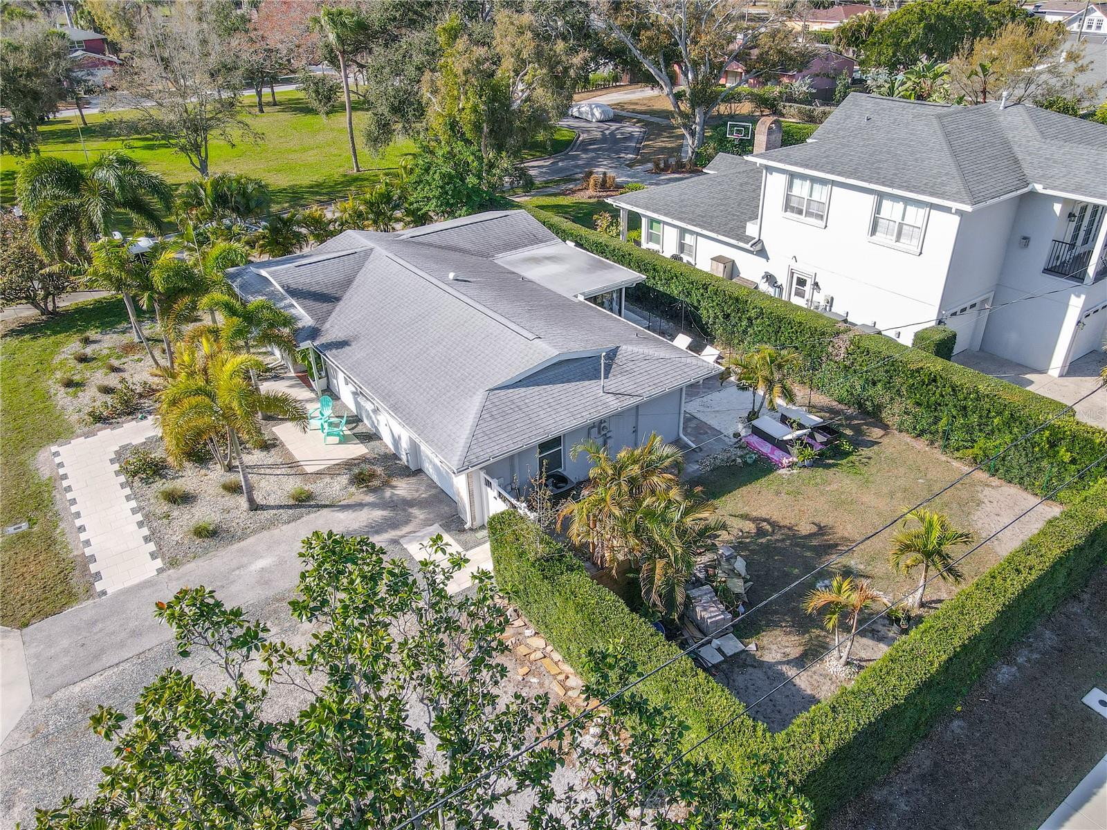 Mature palm trees and established tropical landscaping frame the home beautifully, complemented by a defined walkway leading to the front entrance. The low-maintenance yard design enhances both aesthetics and functionality, creating a polished yet relaxed curb appeal.