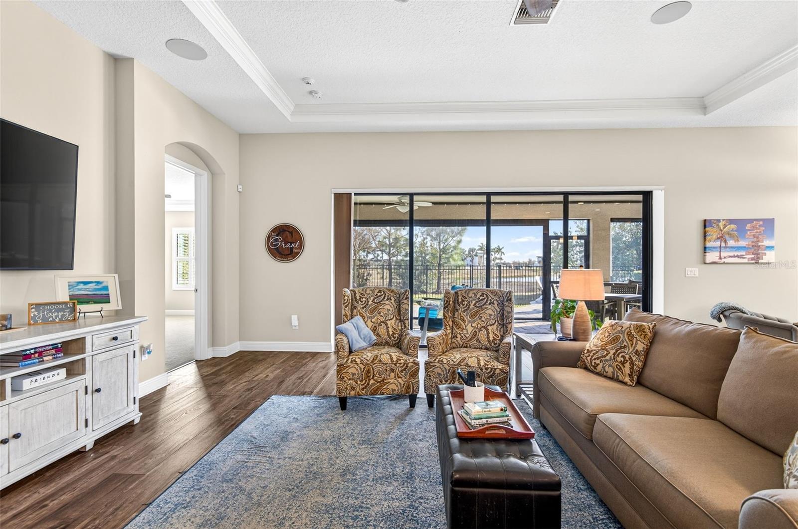 Living area with triple sliding doors on to covered lanai. Ceiling fan