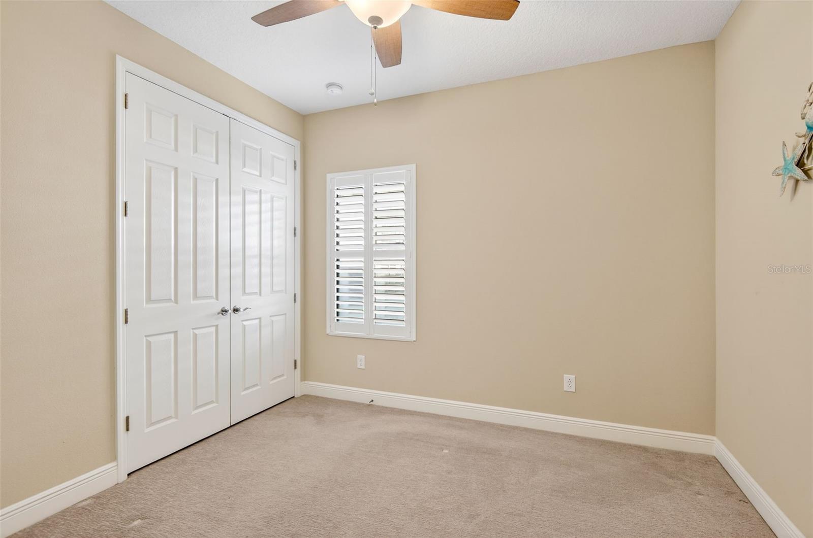 Bedroom #3 with built in closet, ceiling fan, plantation shutters