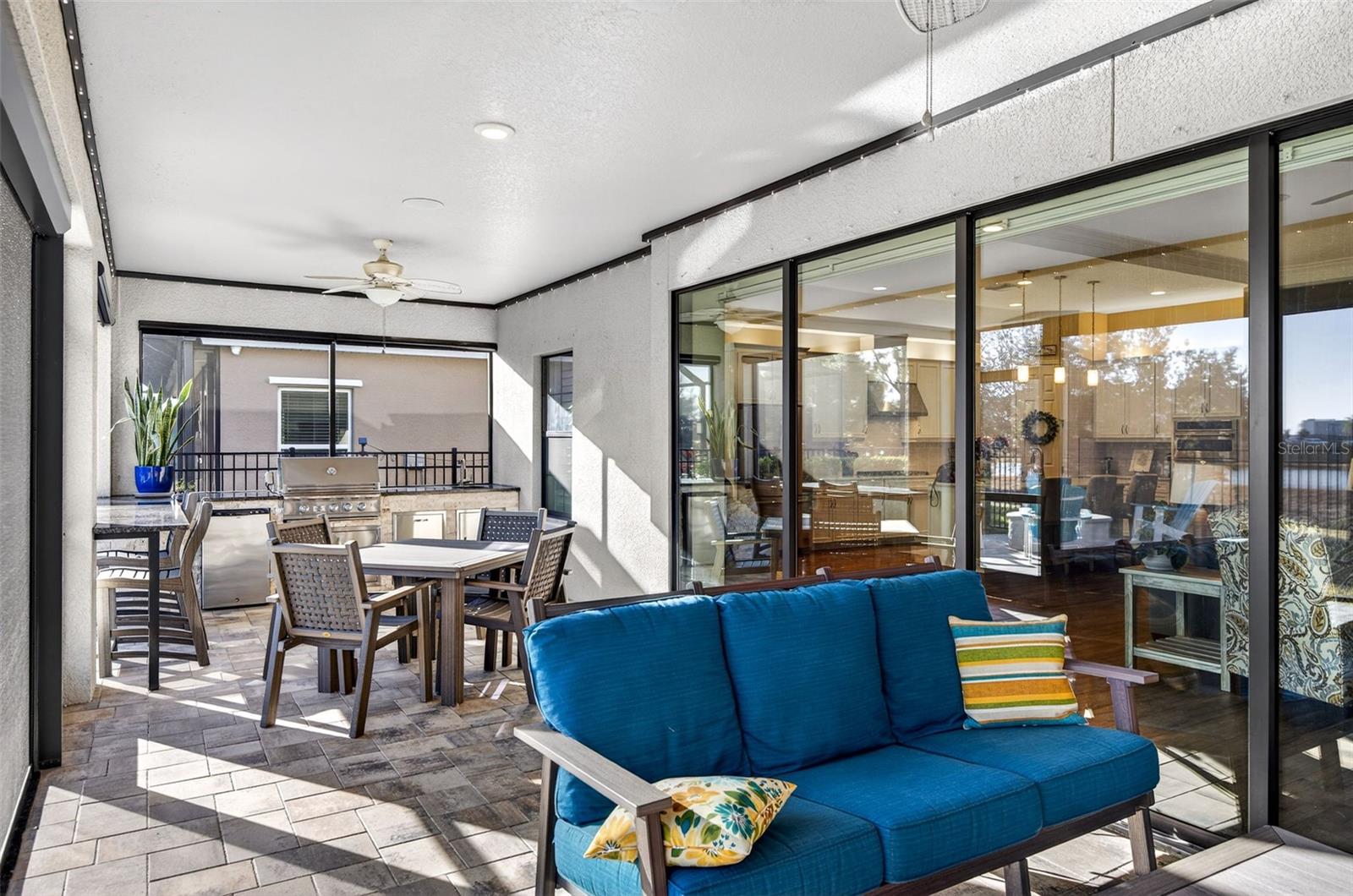 Lanai with ceiling fans, triple sliding glass doors in to living area, trim lights. Plenty of area for seating.