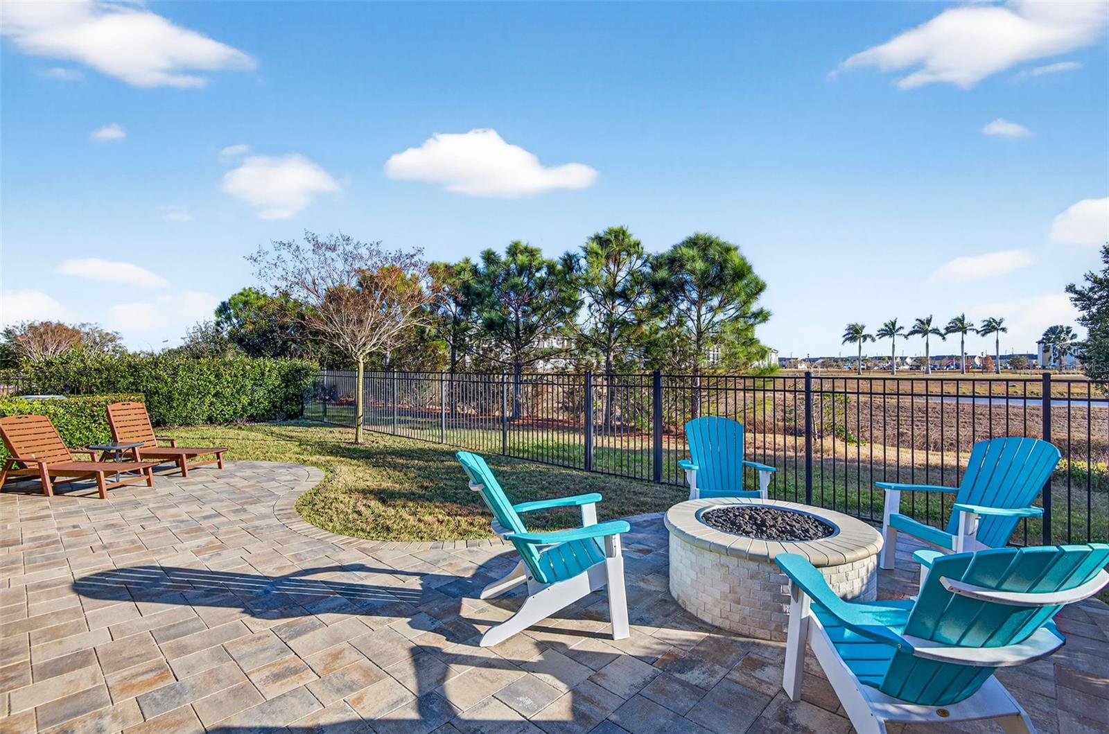 Backyard is fully fenced and features an extended pavered area with gas firepit.