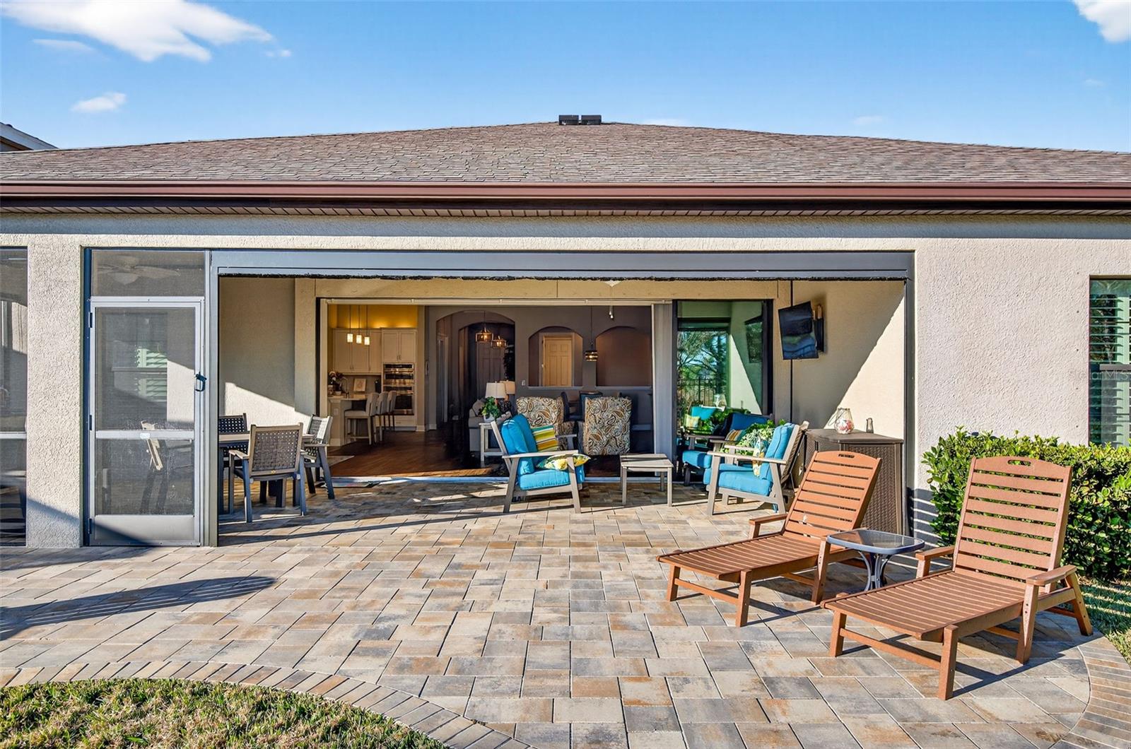 View from backyard in to the lanai and house with the screen fully raised.