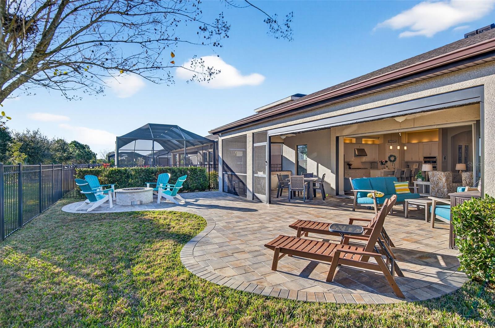 Extended pavered area includes a fire pit and plenty of space for lounging.