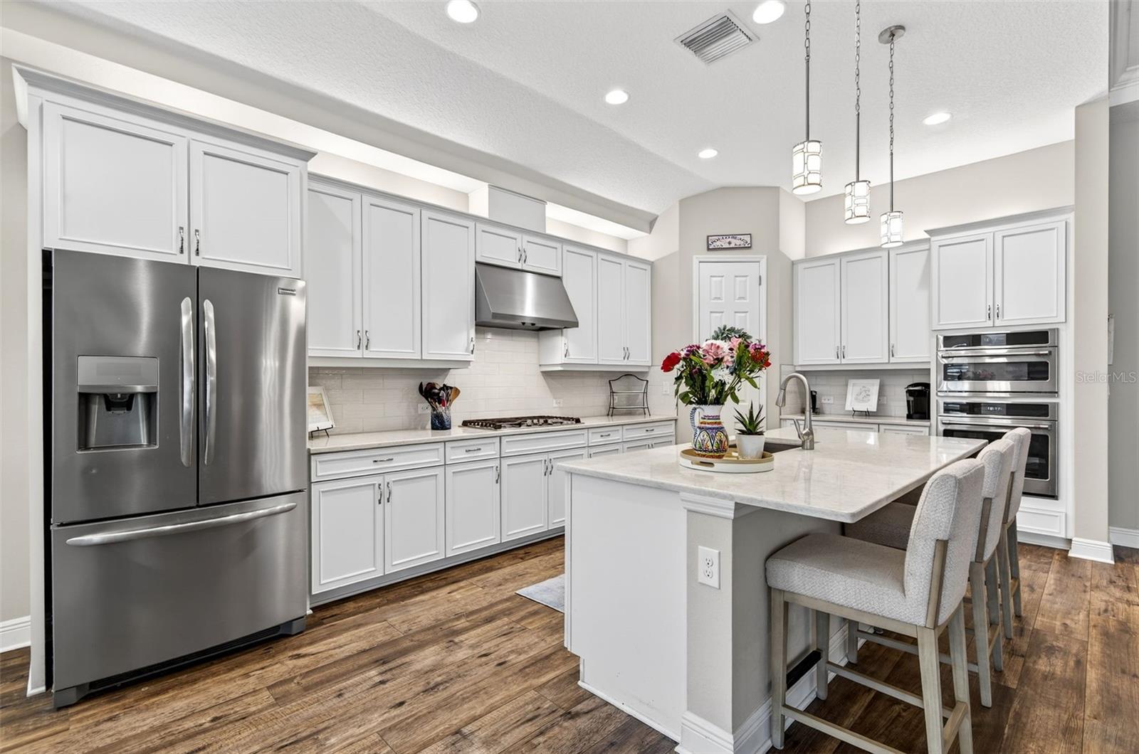 Gourmet Kitchen with stainless steel appliances and hooded range to exterior
