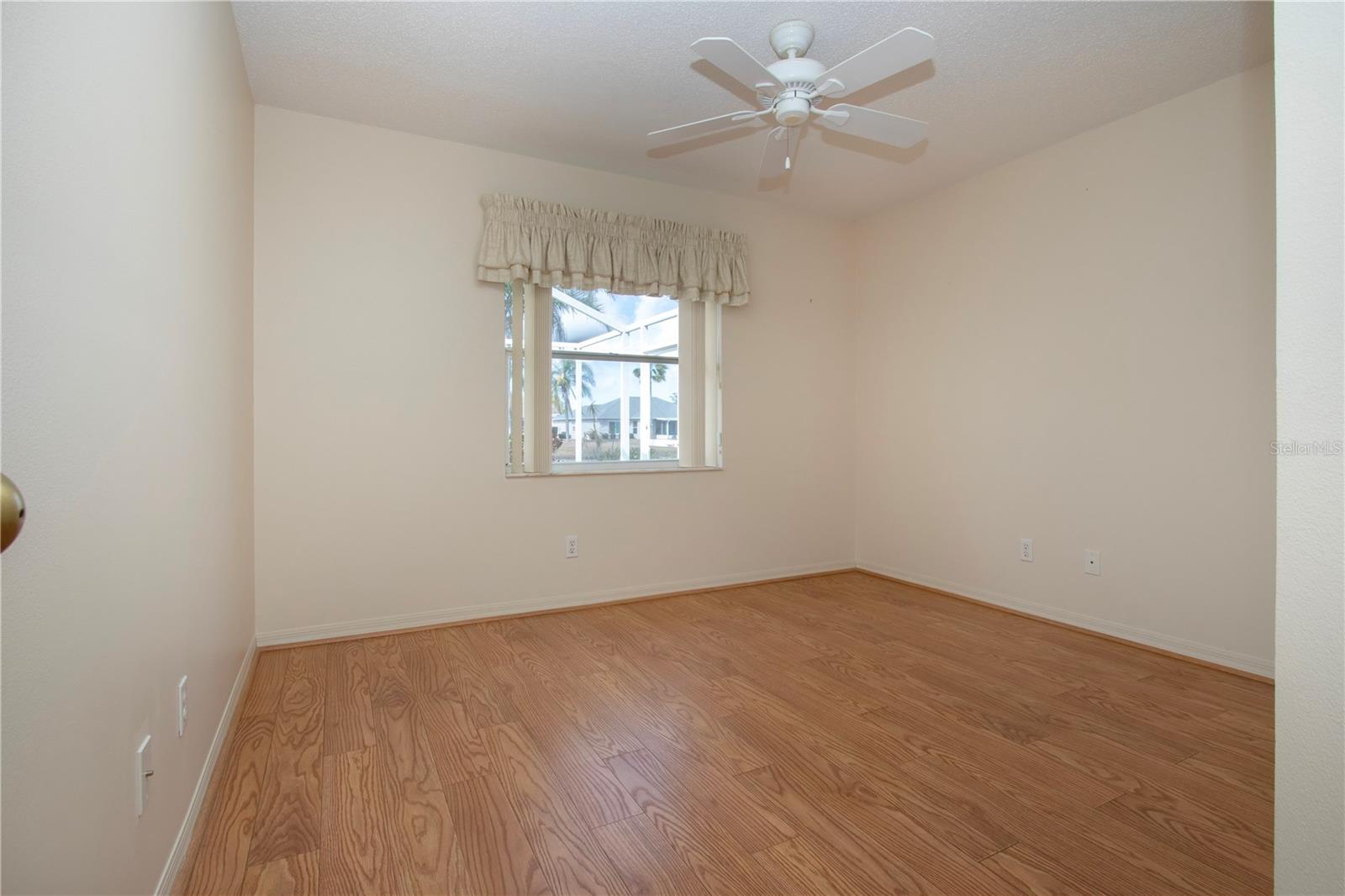 Bedroom three with lanai and backyard view