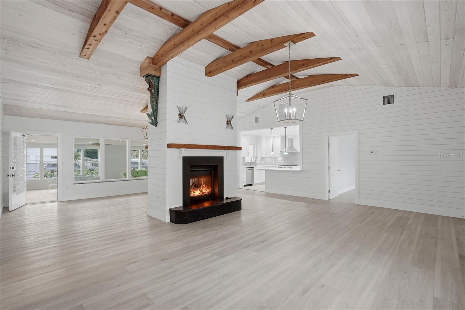 living room with Soaring vaulted ceilings complemented by a stunning double-sided fireplace