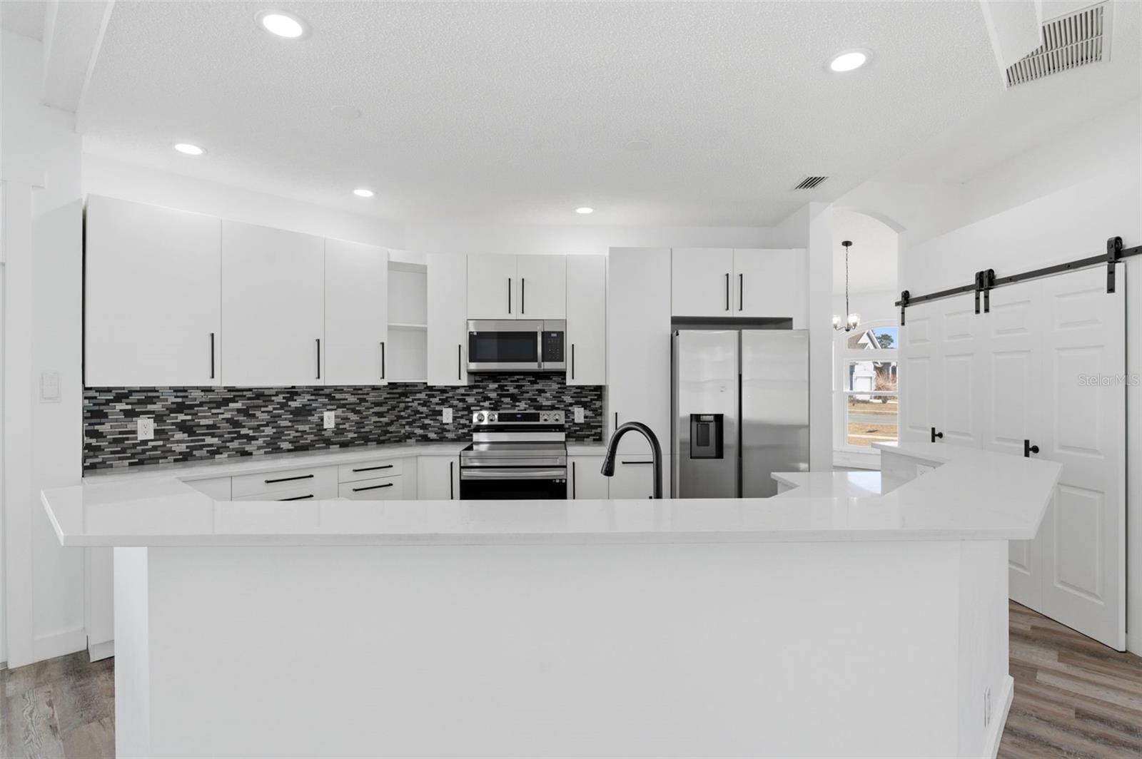 Featuring quartz countertops and a wrap around snack bar.