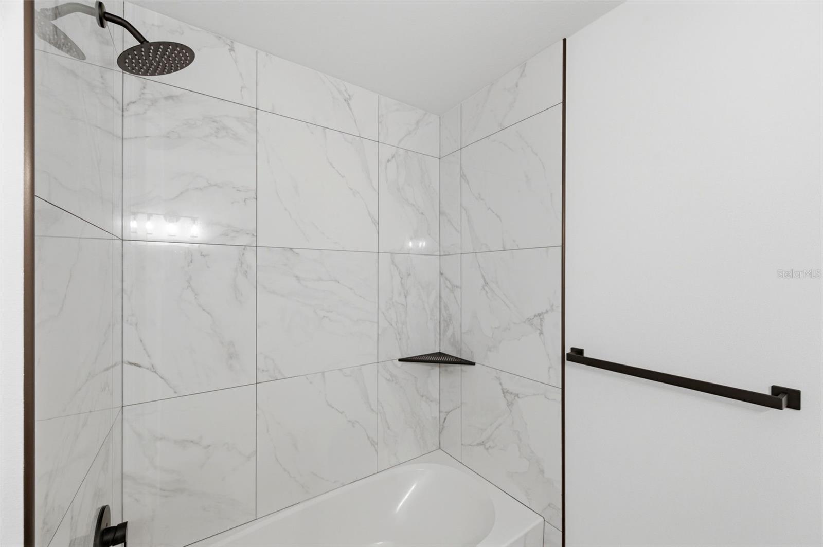 Second bath has tub and shower with tile surround to the ceiling.