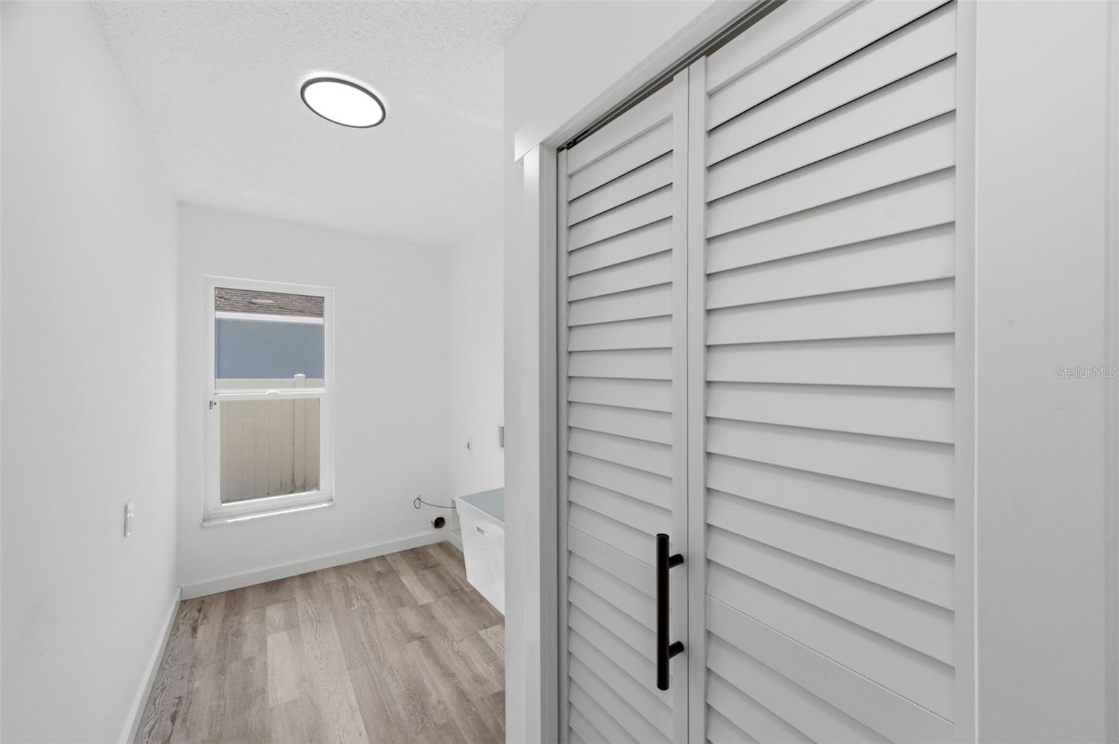 Laundry room with extra storage and deep tub sink.