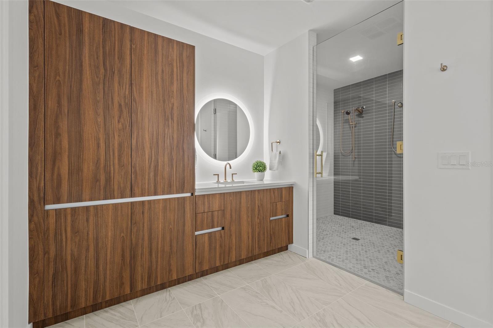 Spa-like primary bathroom with dual gold showerheads, elegant finishes, and a luxurious, modern design.