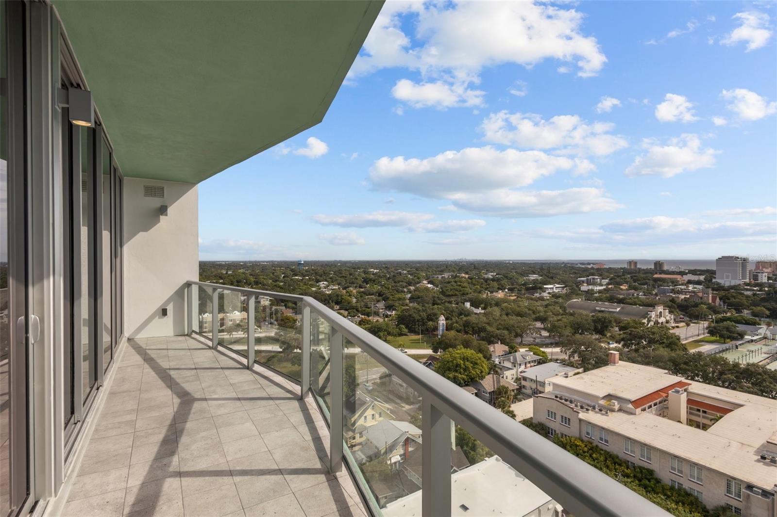 Expansive 30-foot-wide private balcony showcasing breathtaking views of Tampa Bay, the St. Pete skyline, and the Sunshine Skyway Bridge.