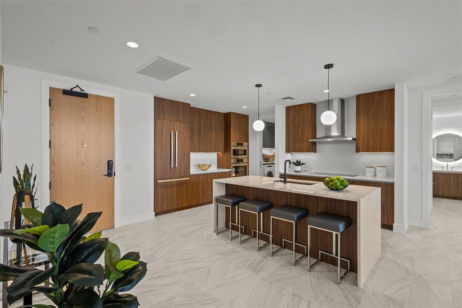 Chef-inspired kitchen featuring Bosch appliances, quartz waterfall-edge countertops, panel-ready cabinetry, and the premium Walnut Upgrade Package. Room for a drop zone when entering opposite of kitchen