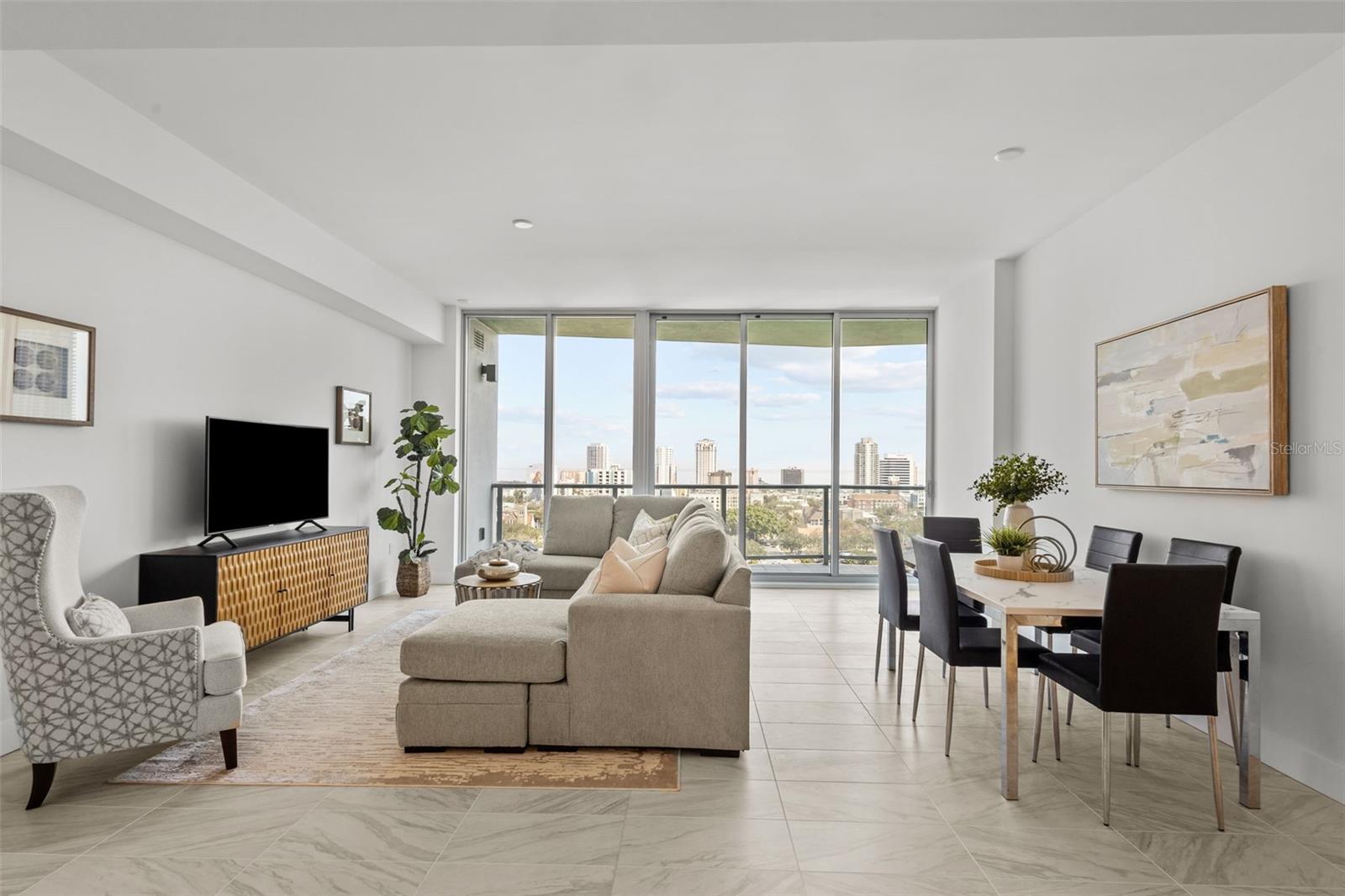 Massive open-concept great room with 10-foot ceilings and floor-to-ceiling windows flooding the space with natural light and stunning views.