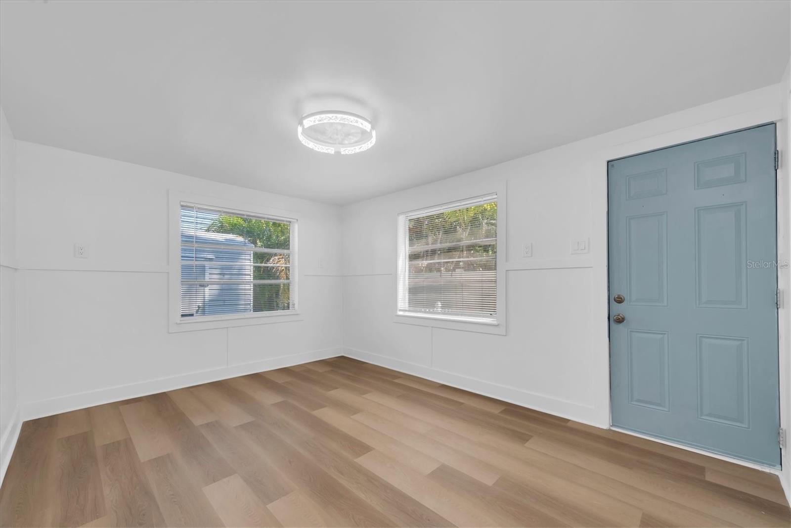 Bedroom 1 - Luxury Vinyl Tile flooring, his and her closets, and access to outside