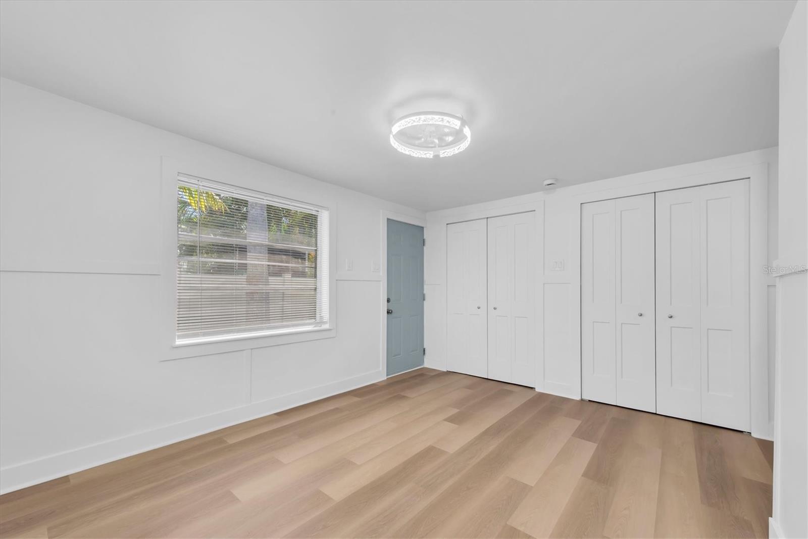 Bedroom 1 - Luxury Vinyl Tile flooring, his and her closets, and access to outside