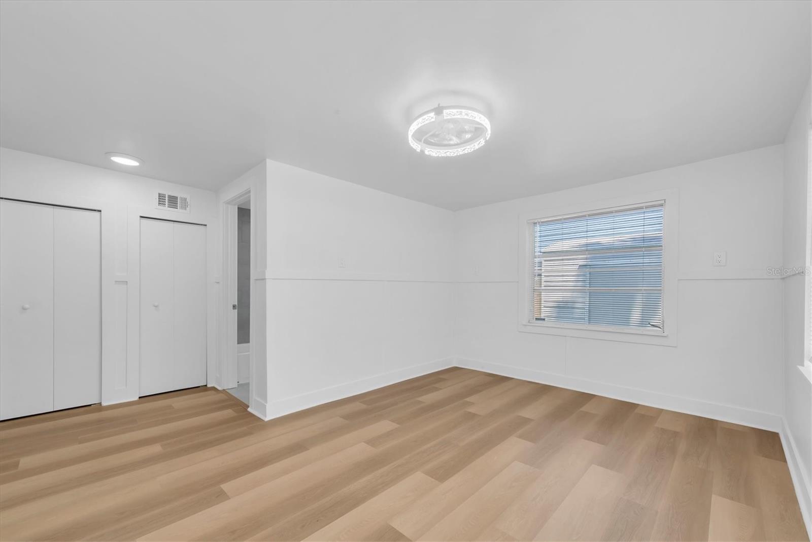 Bedroom 1 - Luxury Vinyl Tile flooring, his and her closets