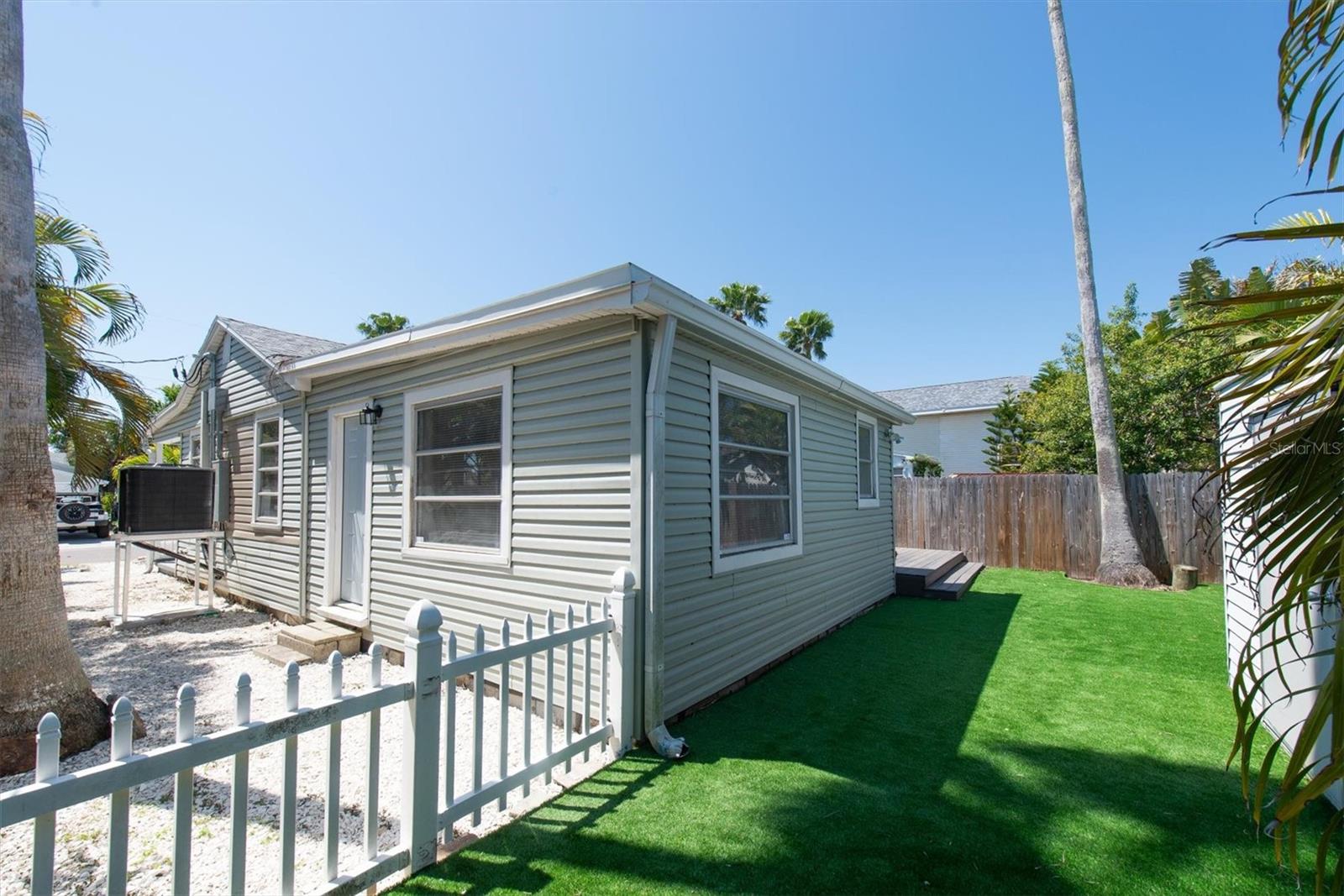 Artificial Turf in Fenced Back Yard for Low Maintenance with storage shed and wood deck.
