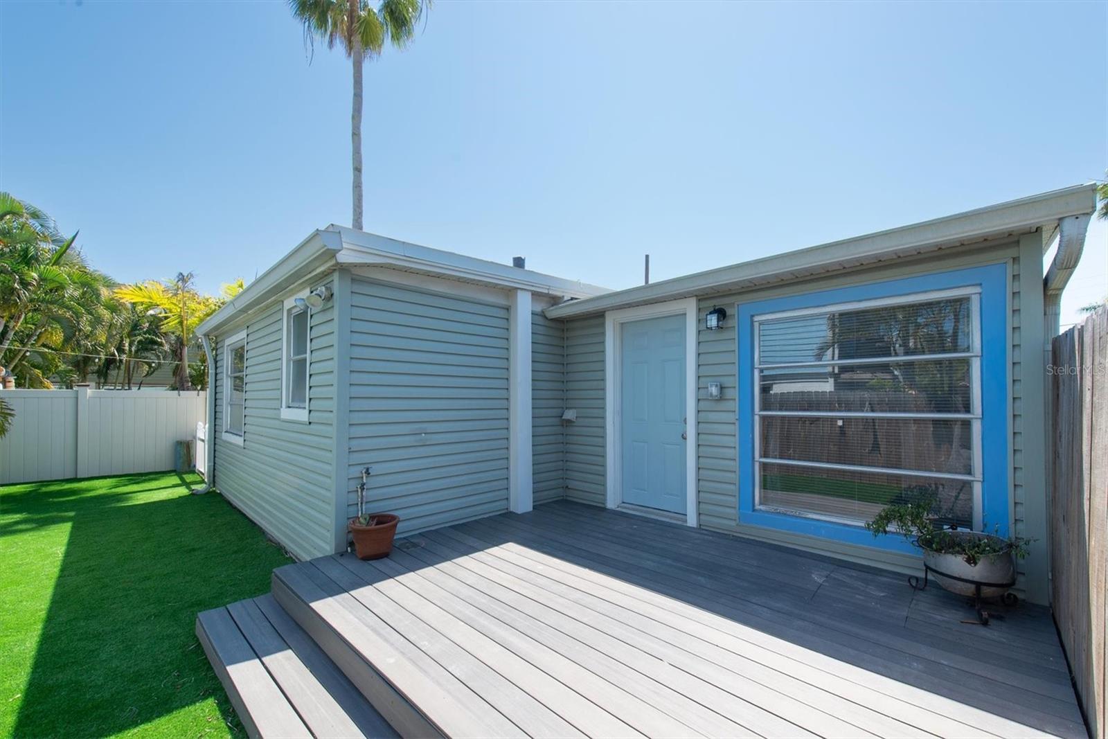 Artificial Turf in Fenced Back Yard for Low Maintenance with storage shed and wood deck.