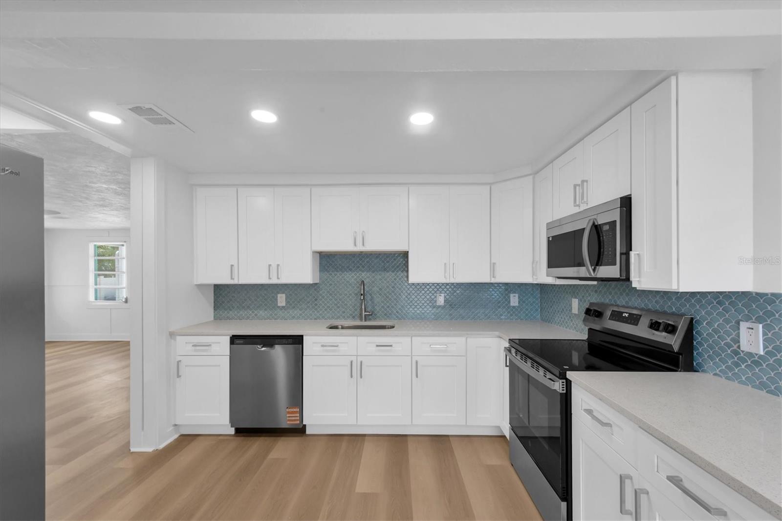 New Kitchen with Quartz Cabinets, white cabinets, tiled backspladh, recessed lighting, stainless steel appliances, including dishwasher