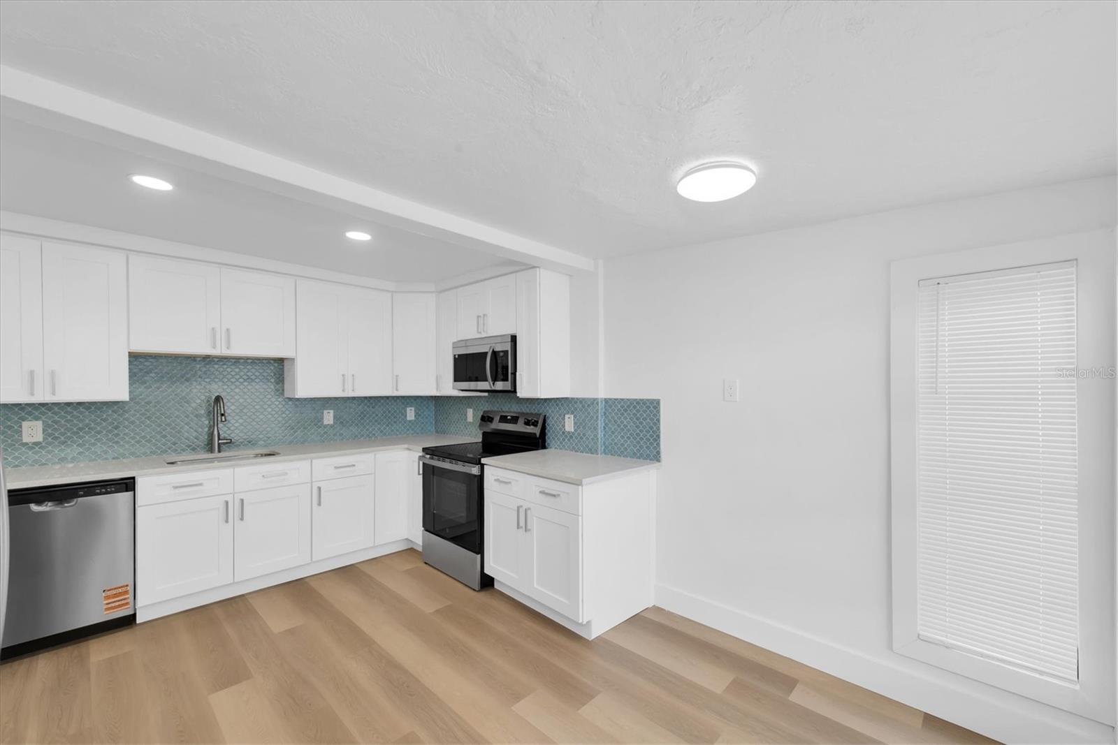 New Kitchen with Quartz Cabinets, white cabinets, tiled backspladh, recessed lighting, stainless steel appliances, including dishwasher