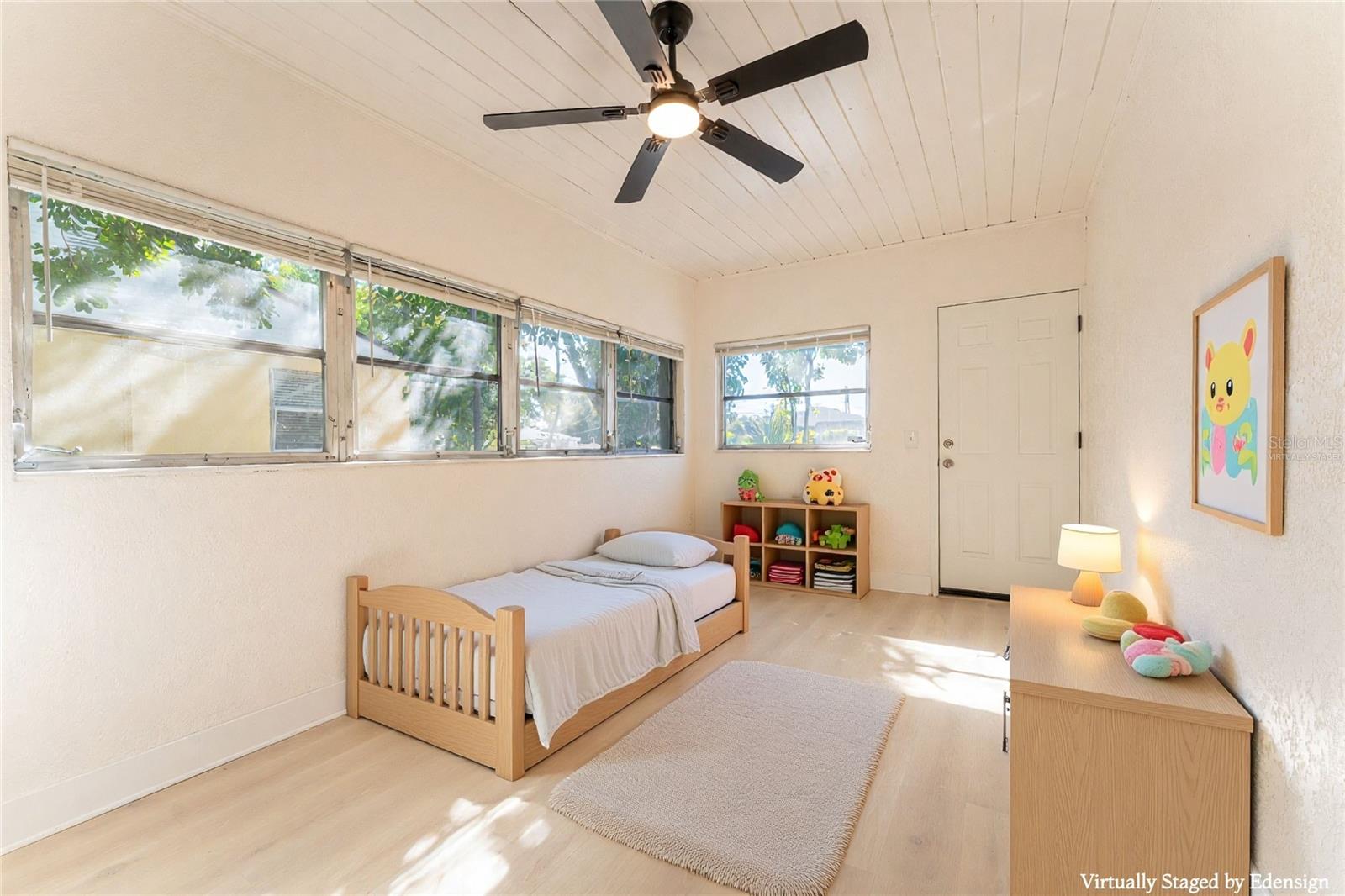 Bedroom #3 features its own private entrance, making it ideal for a guest suite, home office, or potential mother-in-law setup. Bright windows and updated flooring create a light, functional space. Virtually staged.