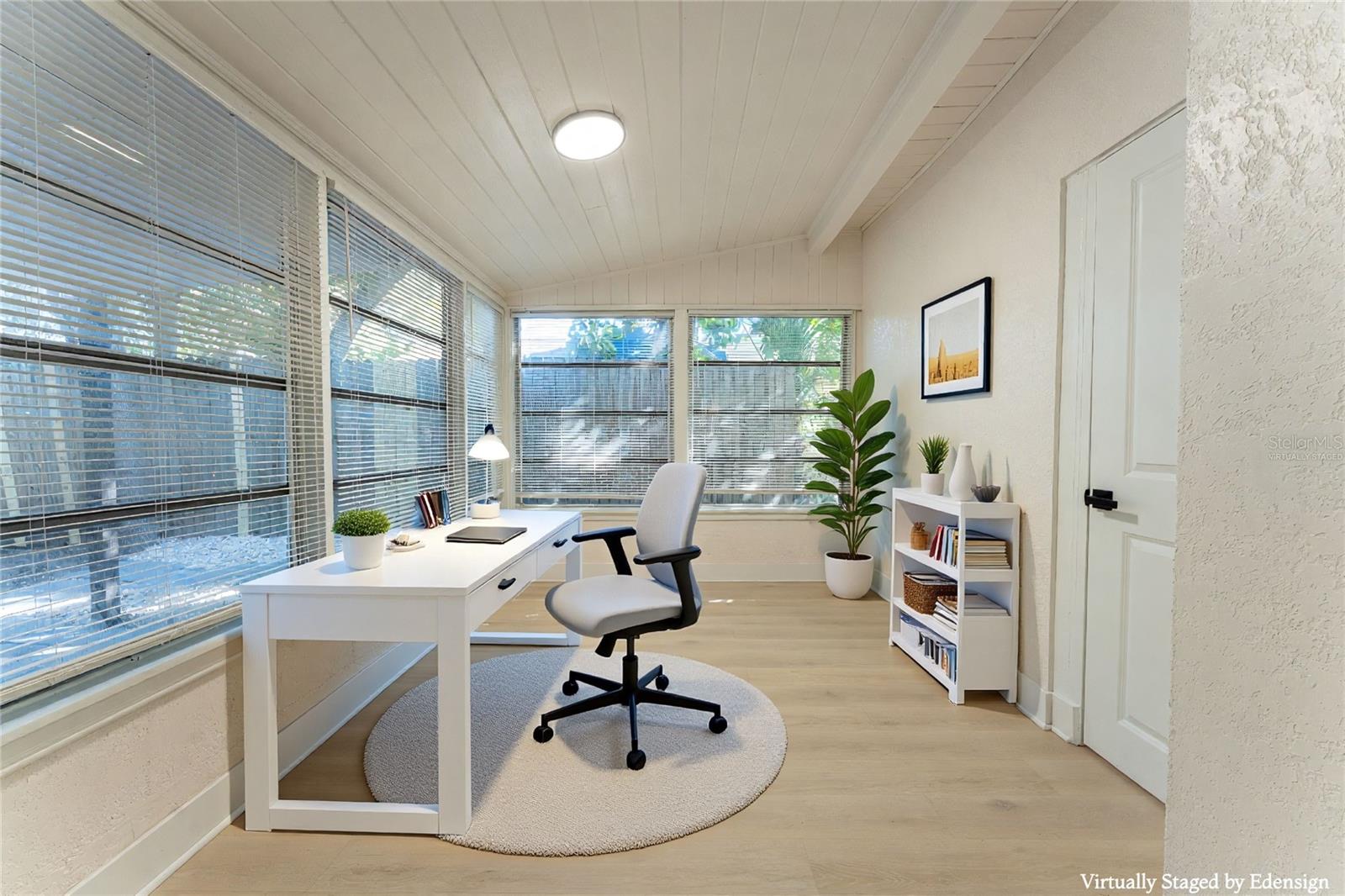 Bright and versatile Florida room filled with natural light from surrounding windows. Ideal for a home office, reading nook, or additional living space to fit your needs. Virtually staged to showcase potential use and layout.