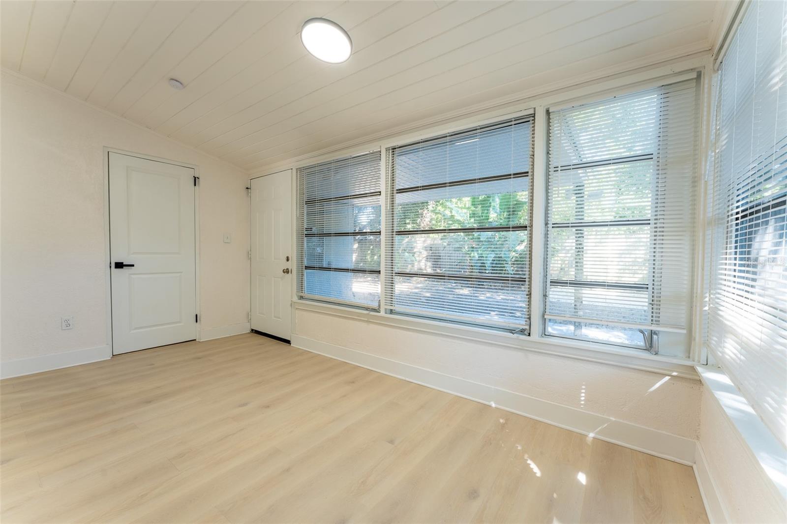 Bright and versatile Florida room filled with natural light from surrounding windows, offering the perfect flex space for an office, lounge, or additional living area. Conveniently includes direct access to a bonus bathroom for added functionality.