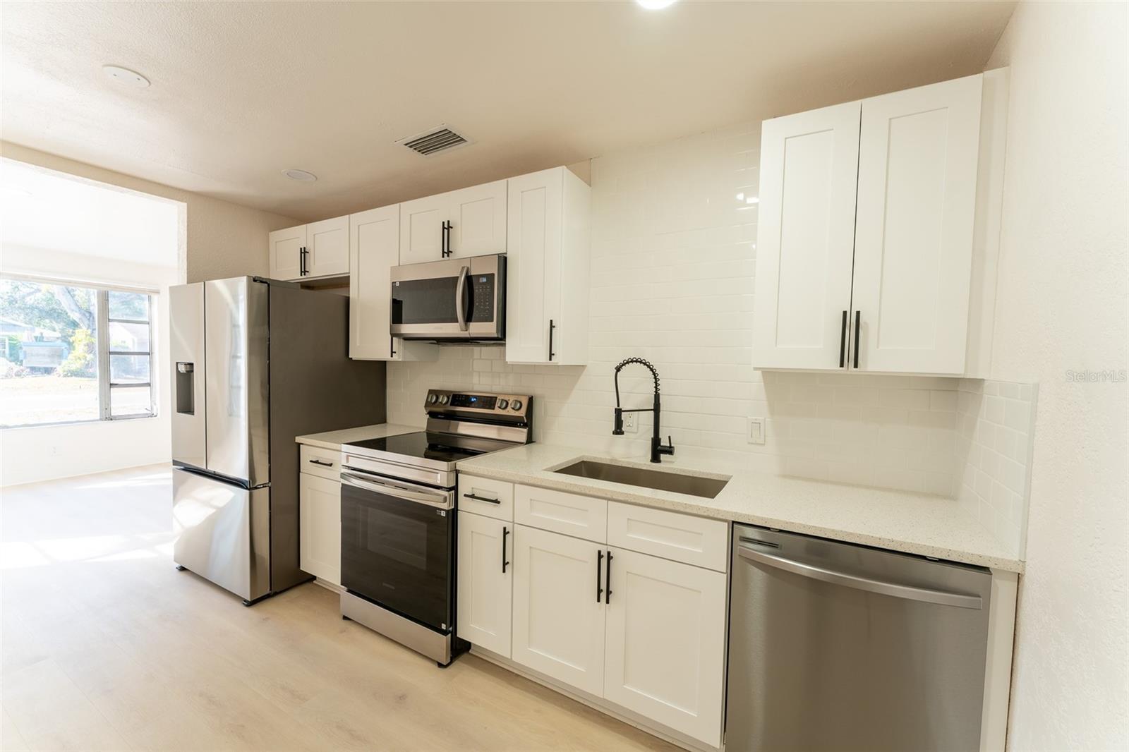 Beautifully updated kitchen featuring brand new stainless steel appliances, modern cabinetry, and sleek countertops. Designed with both style and functionality in mind, this space offers storage,  prep area, and a clean, contemporary feel that flows seamlessly into the main living space — perfect for everyday living and entertaining.