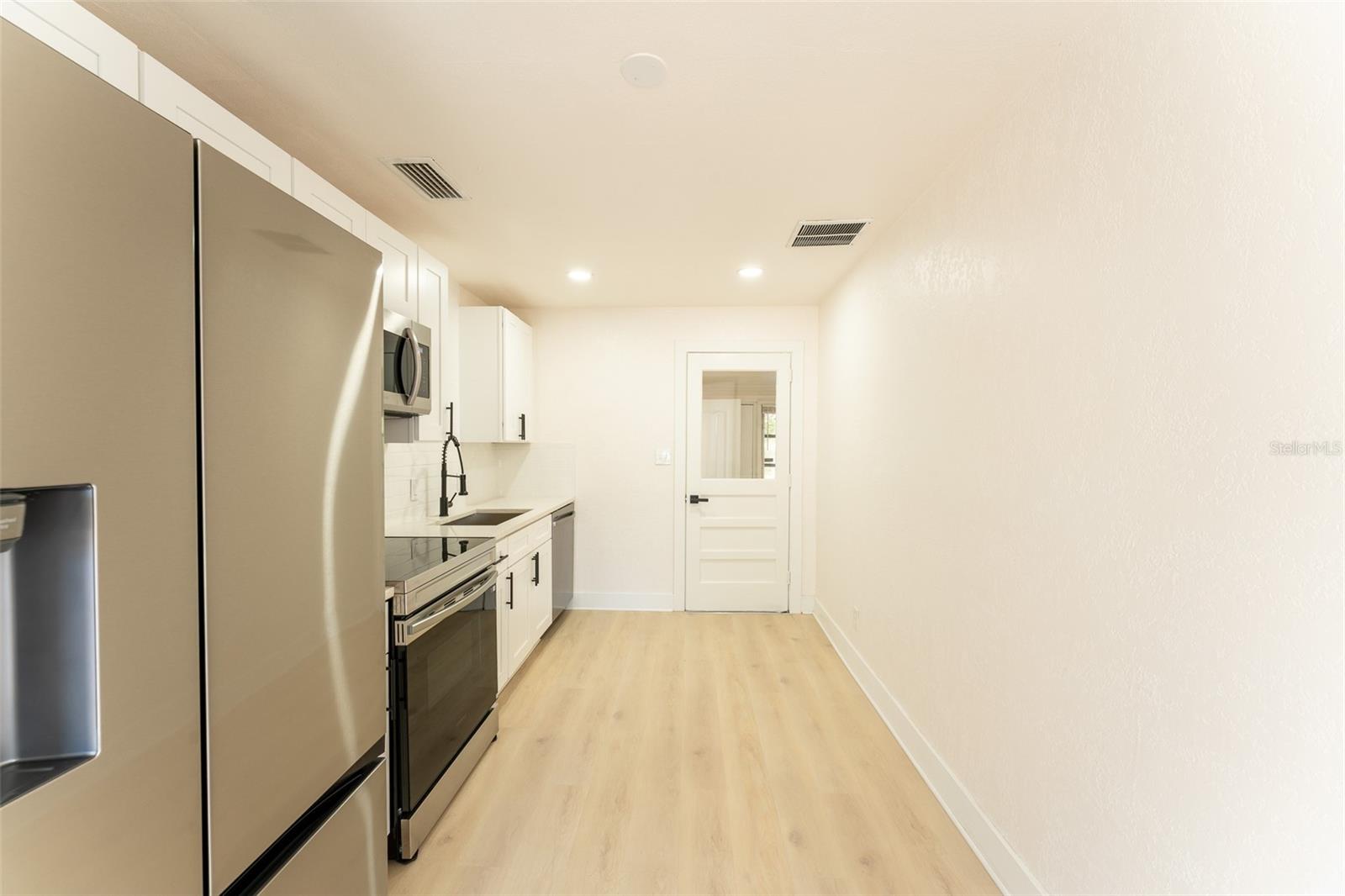 Kitchen offers seamless flow into the bright Florida Room, creating an open and connected layout ideal for everyday living or entertaining. Easy access between spaces enhances functionality and expands your living area.