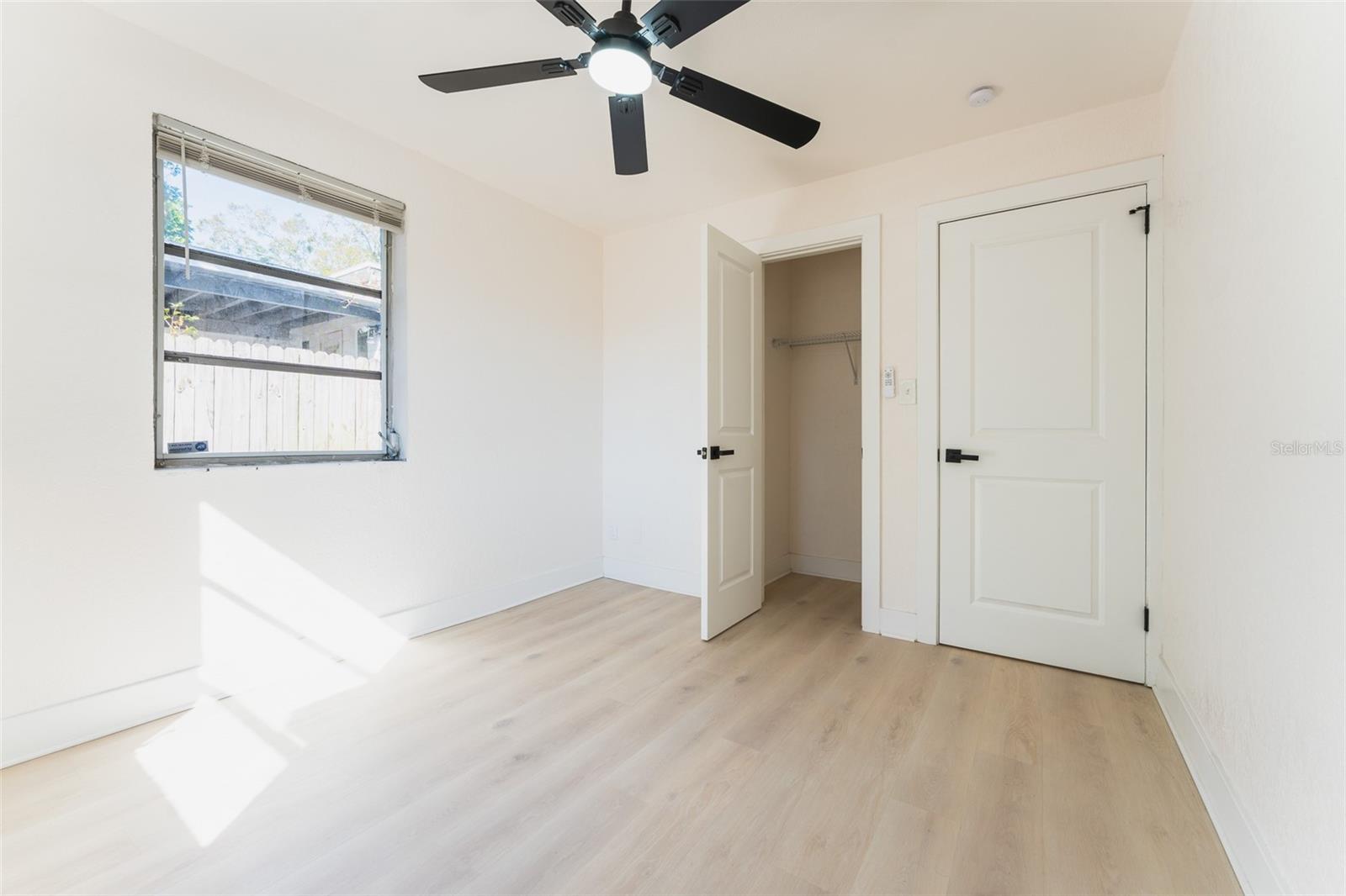 Bedroom #1 - Light and airy bedroom with updated flooring, modern ceiling fan, and closet storage. A clean, versatile space ready for your personal touch.