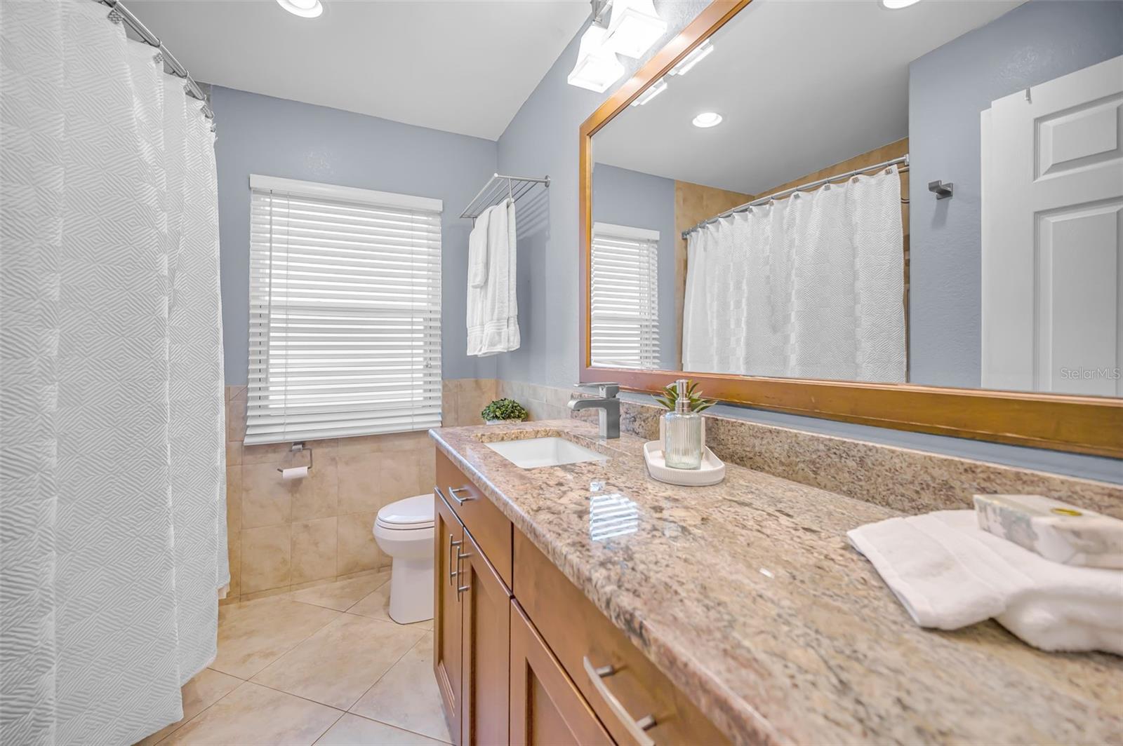 Updated second bath with tub/shower combo and granite counter