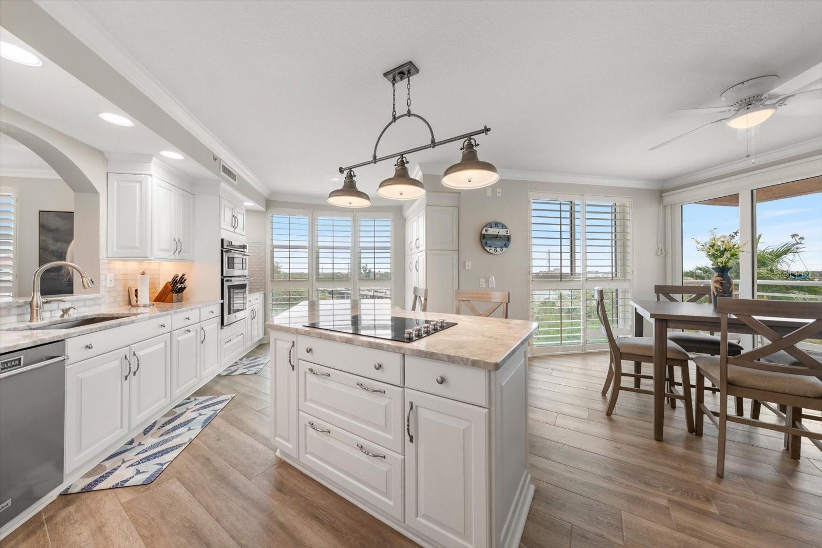 Light and bright kitchen, island with cooktop offers additional cabinetry
