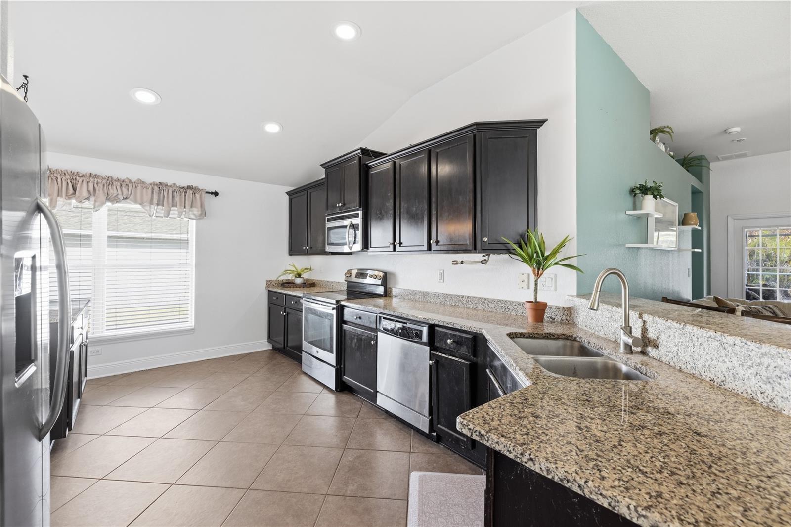 Expansive kitchen with granite counter tops and stainless steel appliances