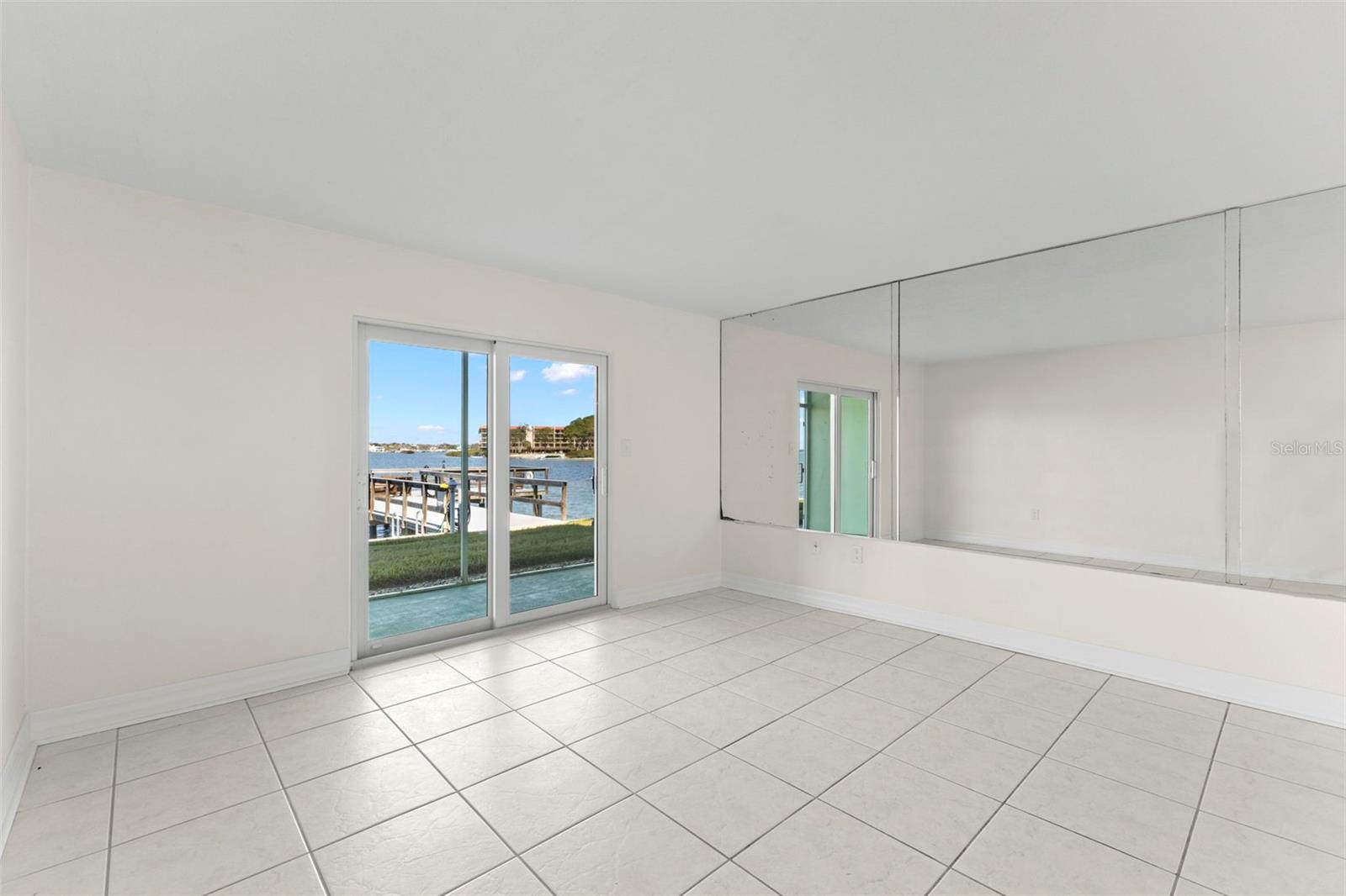 Enjoy peaceful Intracoastal scenery from your living room, where natural light, tile flooring, and direct waterfront access define the space.