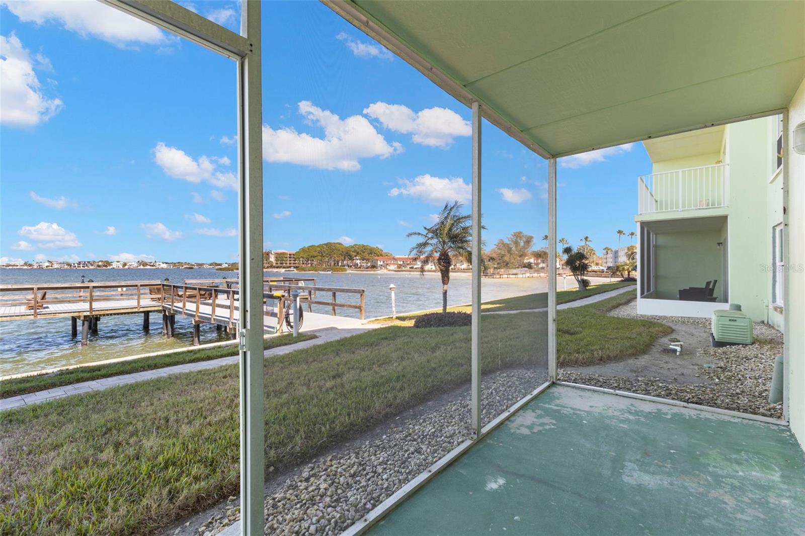 Relax on your screened patio while taking in waterfront views, gentle breezes, and immediate access to the dock and coastal walking path.