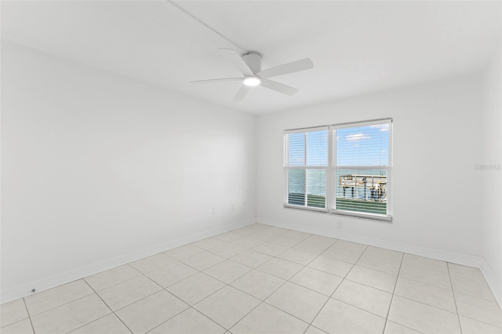 Wake up to Intracoastal views from this bright bedroom, complete with tile flooring and modern ceiling fan.